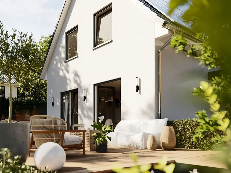 Terrasse des Raumwunder 90 – gemütlicher Rückzugsort im Grünen Detailansicht der Holzterrasse vom Raumwunder 90 mit Sitzmöbeln und Pflanzendekoration im Tageslicht